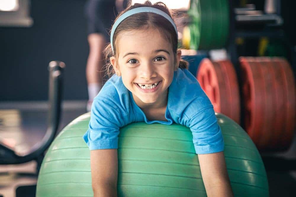 Young girl on a bouncing ball for physiotherapy